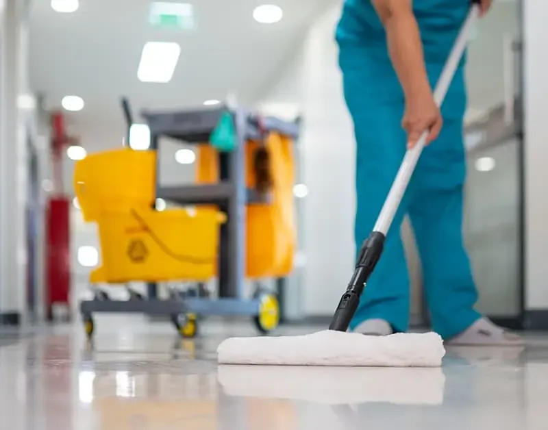 A staff member professionally cleaning office floors