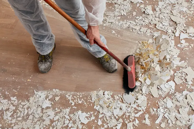 Someone sweeping drywall dust during post-construction cleaning